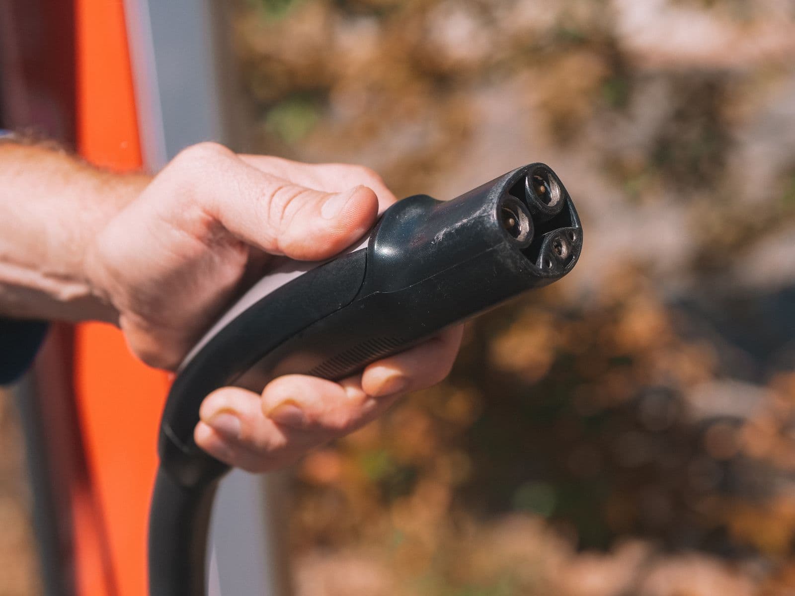A hand holding a CCS DC fast-charging connector